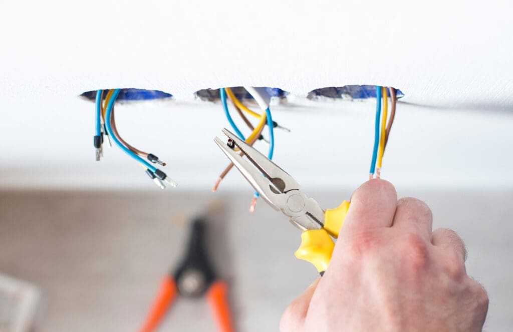 Male hands repair the socket